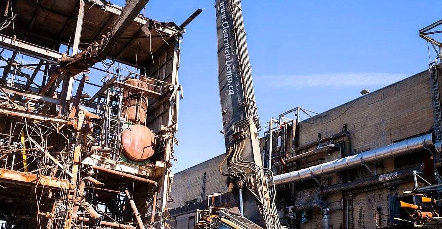 حفار بذراع طويل أثناء هدم منشأة خرسانية